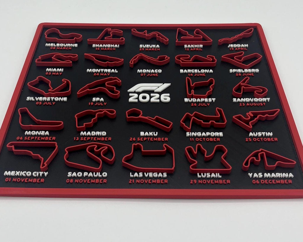 A red and black 2026 Formula 1 calendar plaque featuring all twenty races of the season with their circuit tracks, dates, and names printed in white. The center features the 'F1 2026' logo.