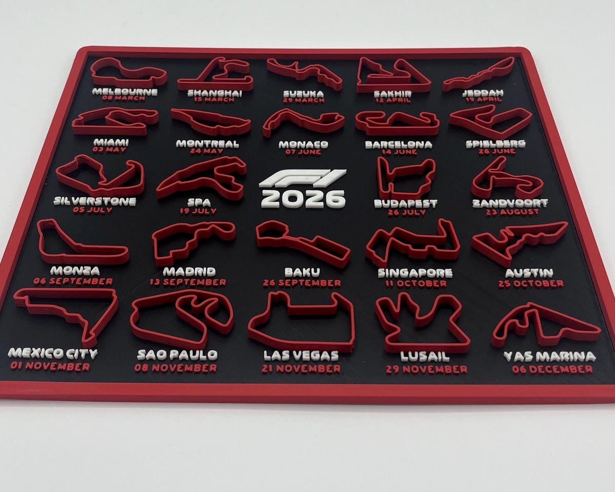 A red and black 2026 Formula 1 calendar plaque featuring all twenty races of the season with their circuit tracks, dates, and names printed in white. The center features the 'F1 2026' logo.