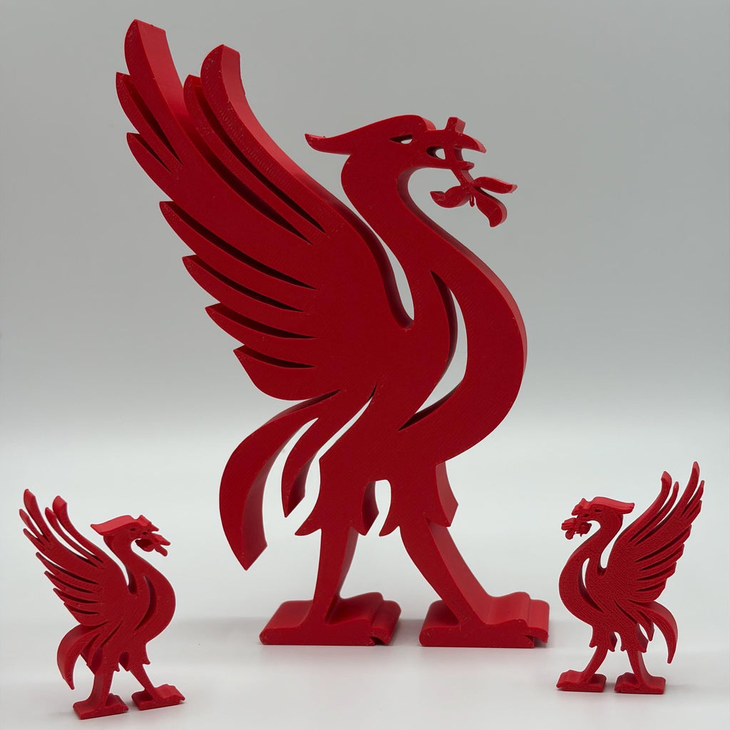 Three red Liverpool FC bird figurines in different sizes displayed on a light grey background.