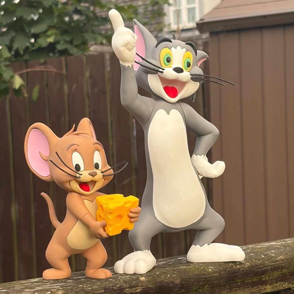 A Tom and Jerry figurine set featuring the classic cartoon characters Jerry the mouse and Tom the cat standing on a wooden fence outdoors.