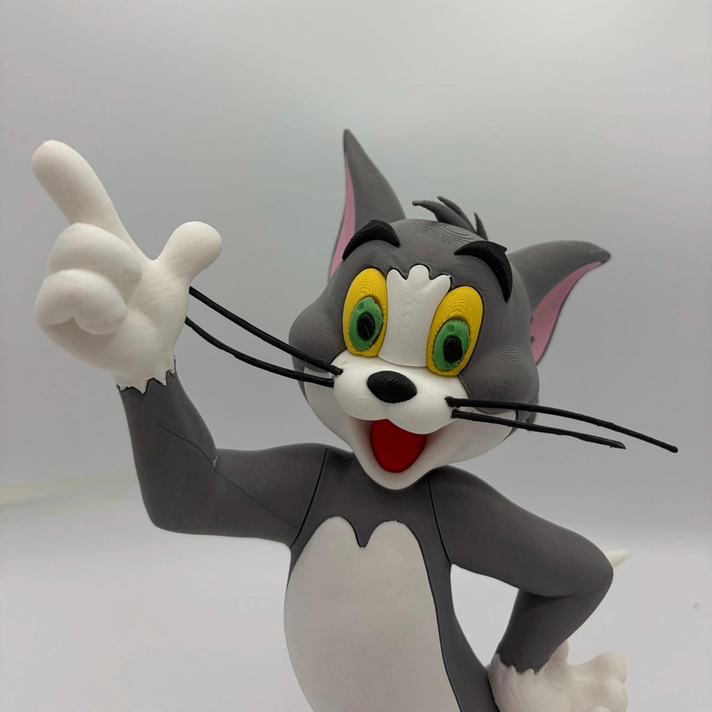 A 3D-printed figurine of Tom and Jerry's favorite cat, Tom, pointing upwards with a white background.
