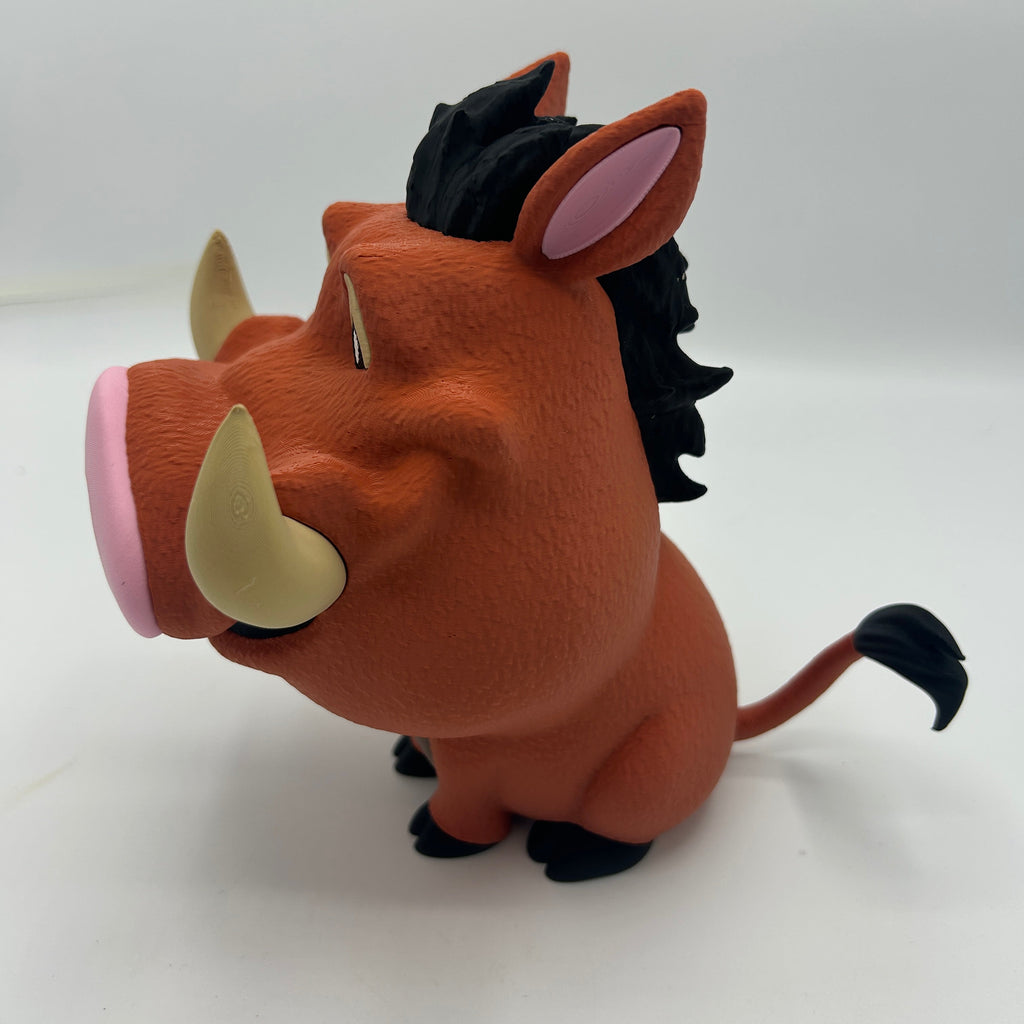 A stylized, cartoonish figurine of Pumbaa from The Lion King, featuring a brown body, black mane and tail, pink snout and ears, and beige tusks, set against a plain white background.