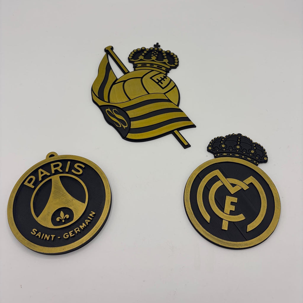 Three Paris Saint-Germain FC themed stickers or decals on a plain white background: a circular PSG emblem, a central crest with a crown and flag, and a circular Real Madrid-style FC logo.
