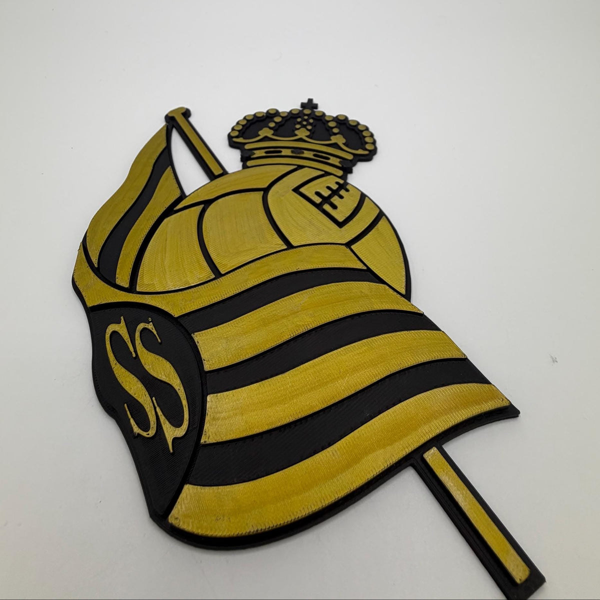 A yellow and black striped embroidered patch featuring a crown, a soccer ball motif, and the letters 'SS' on a white background.