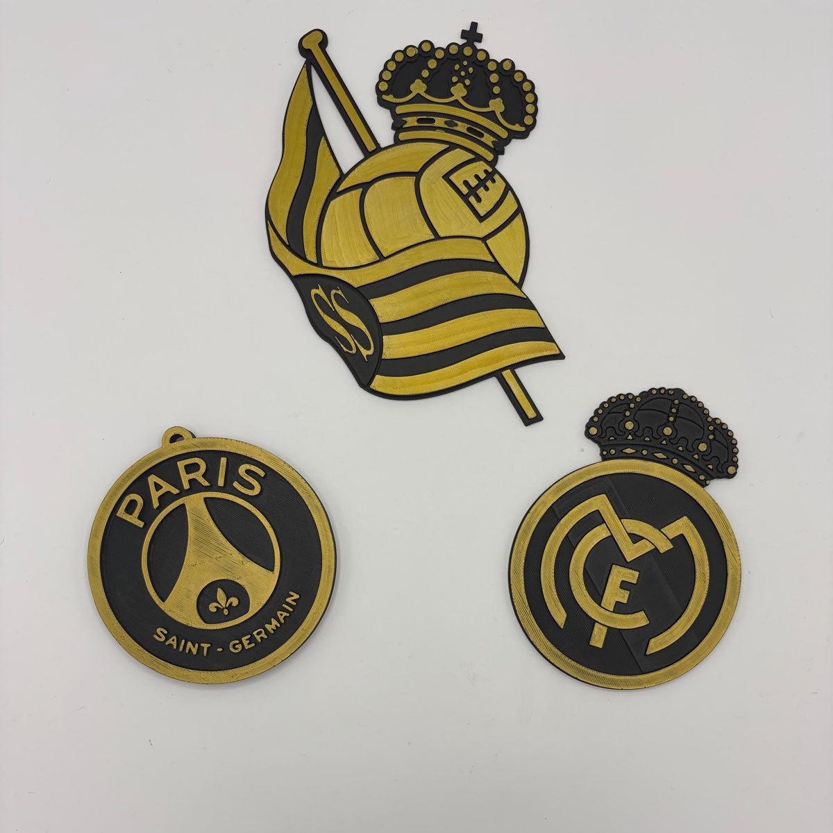 Three Paris Saint-Germain FC themed wall decals or stickers displayed on a white wall, featuring a large crest with a crown and flag, and two circular emblems.