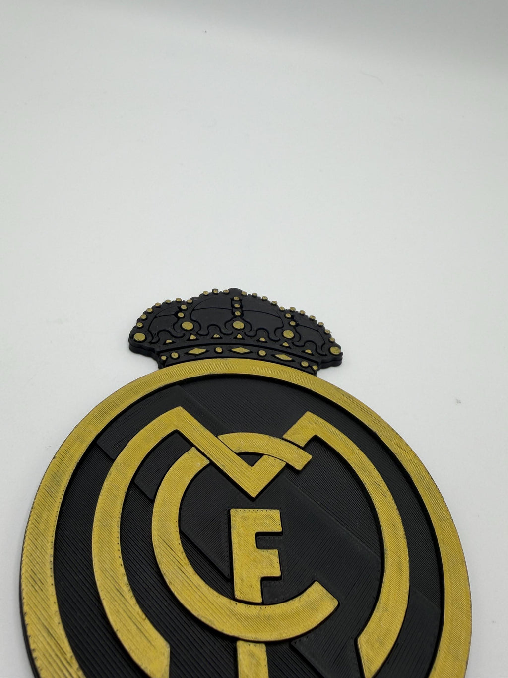 A close-up of a Real Madrid crest emblem with a crown on a plain white background.