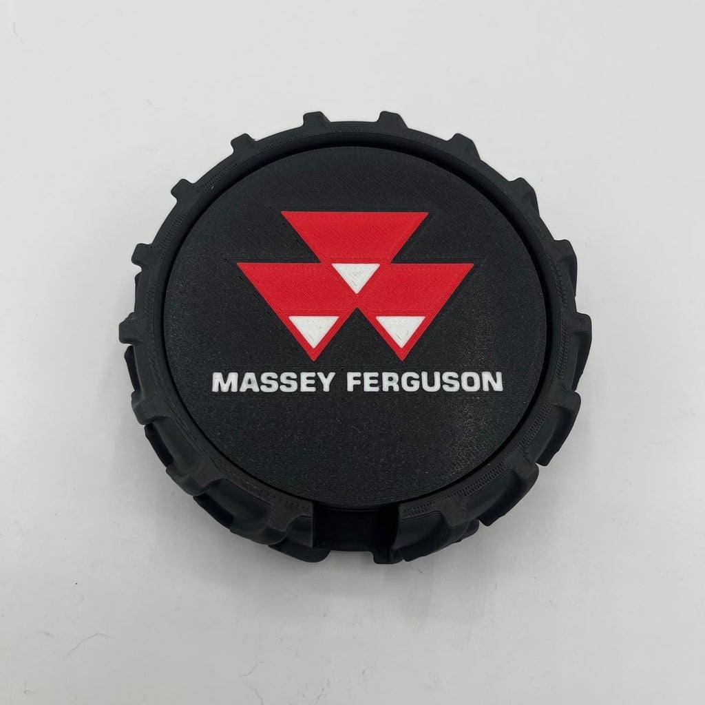 A black circular tyre with a textured outer edge, featuring the red and white Massey Ferguson logo and white text reading 'MASSEY FERGUSON' on a light gray background.